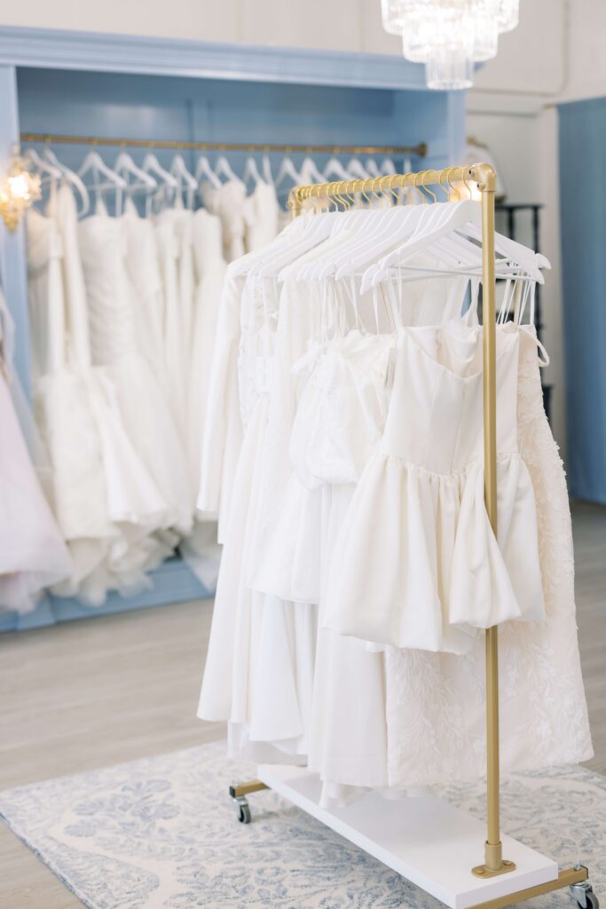 Ready-to-Wear Bridal Gowns, wedding dresses, and little white dresses hung up at Bleu Bridal Co in Bixby, Oklahoma